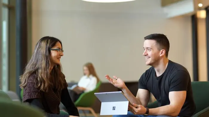 A student talking to a member of staff in the Student Centre