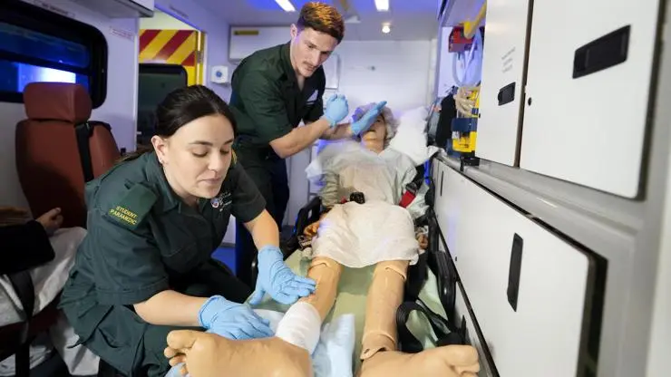 Patient care being simulated in the back of an ambulance.