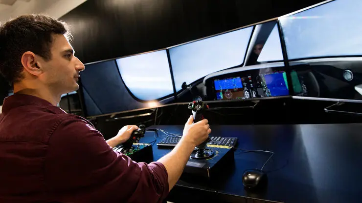 A student working on a flight simulator