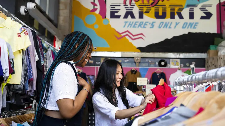 two students looking at vintage clothing