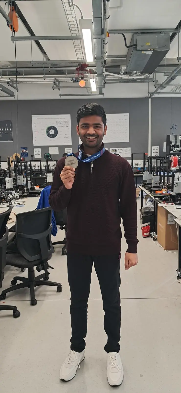 Adhithyan Srinivasan standing with his award