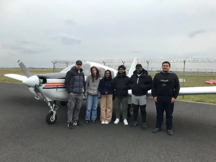 Students stood in front of the plane they flew
