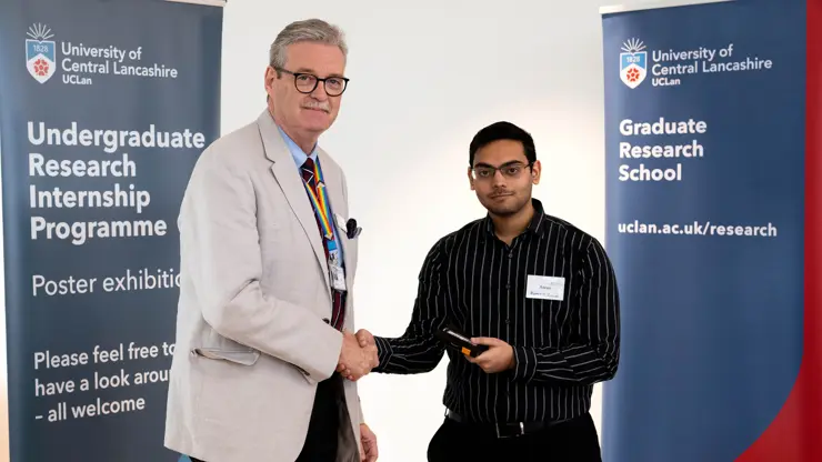 Professor StJohn Crean presenting Aarav Ramesh Kanar with an award. 