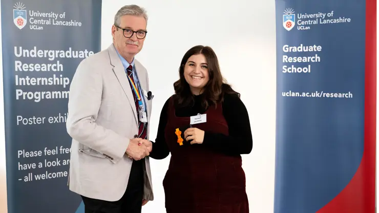 Professor StJohn Crean presenting Hannah Gardiner with an award. 