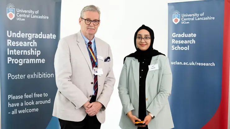 Professor StJohn Crean presenting Iqra Hussain with an award. 