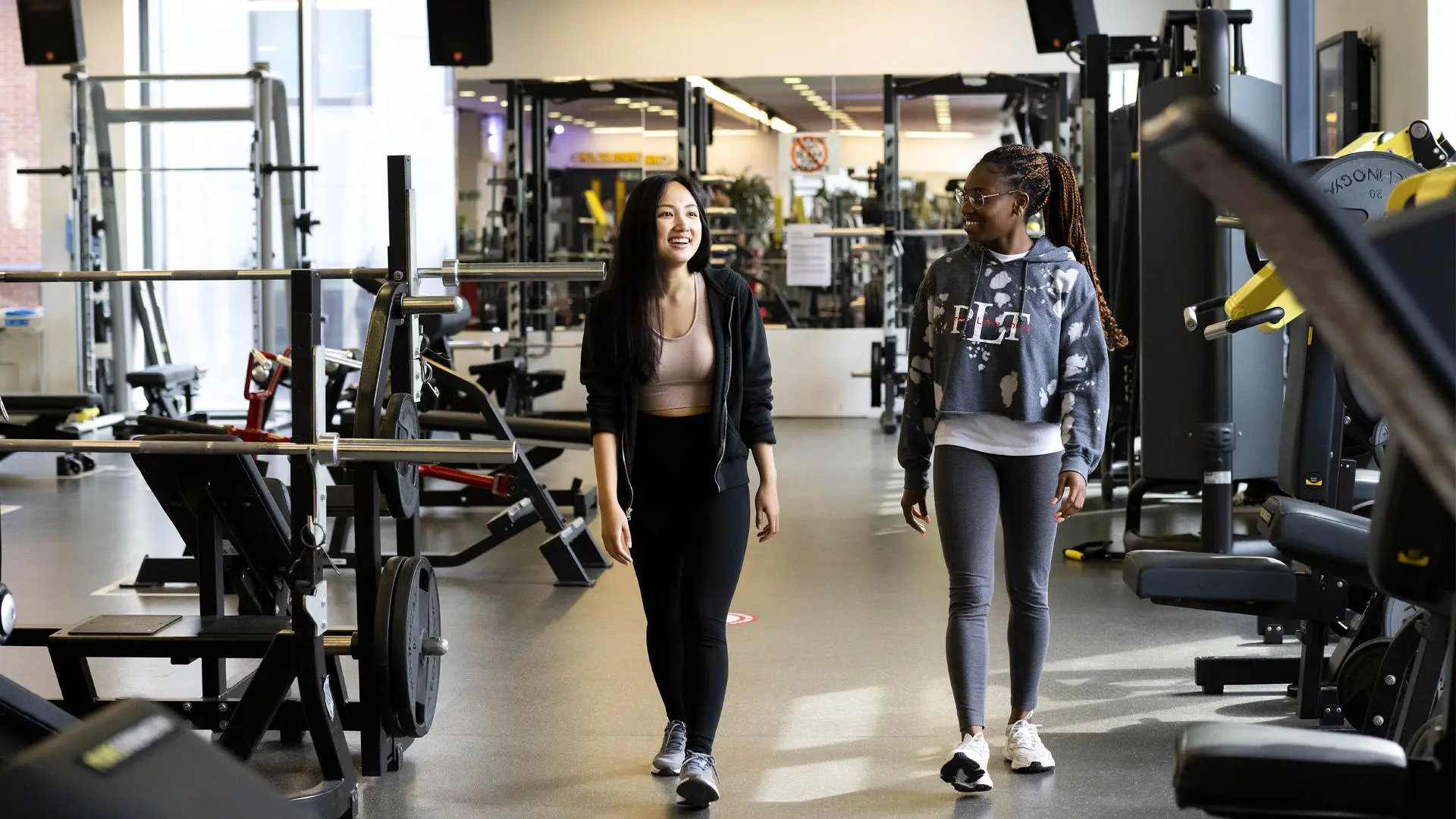 two students walking across the gym floor in sir tom finney sports centre