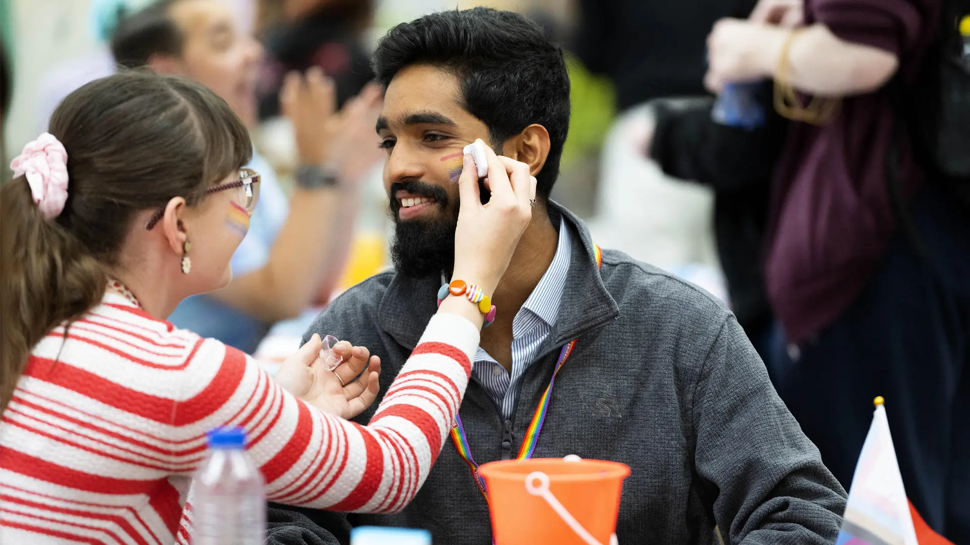 student using facepaint on another student in the students union