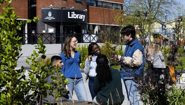 Students standing in a group outside the library building