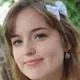 female student smiling at camera with bow in hair