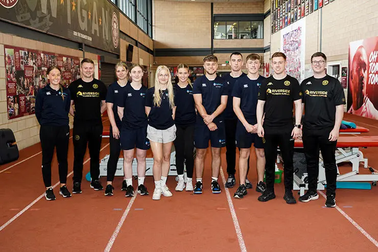 Students stand with Wigan Warriors physiotherapy and sports therapy staff