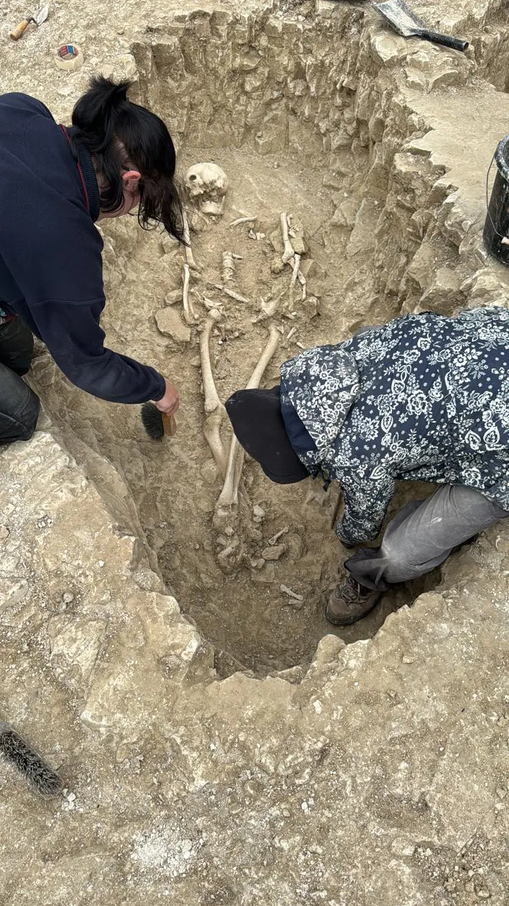 Students excavating a male burials firm within a ring ditch at the site