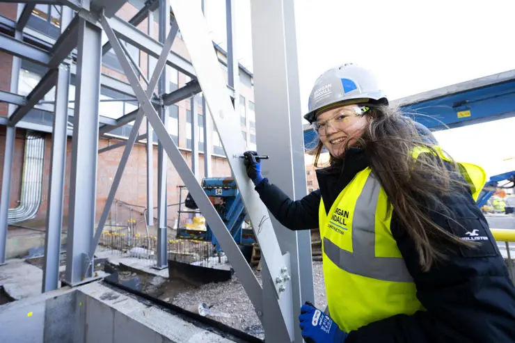 Emma Hall etching her name on to steel the foundations of the new building